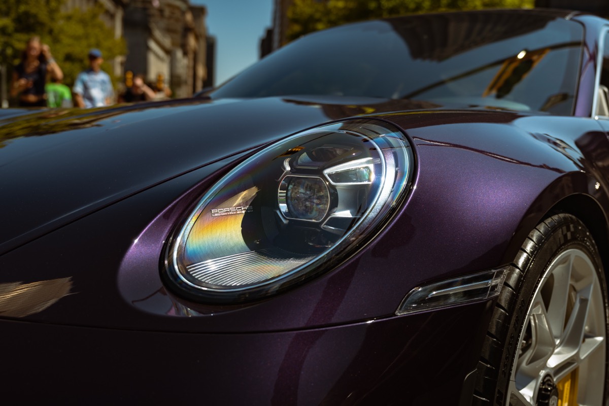 Close-up detail of a Porsche headlight photographed at a car show